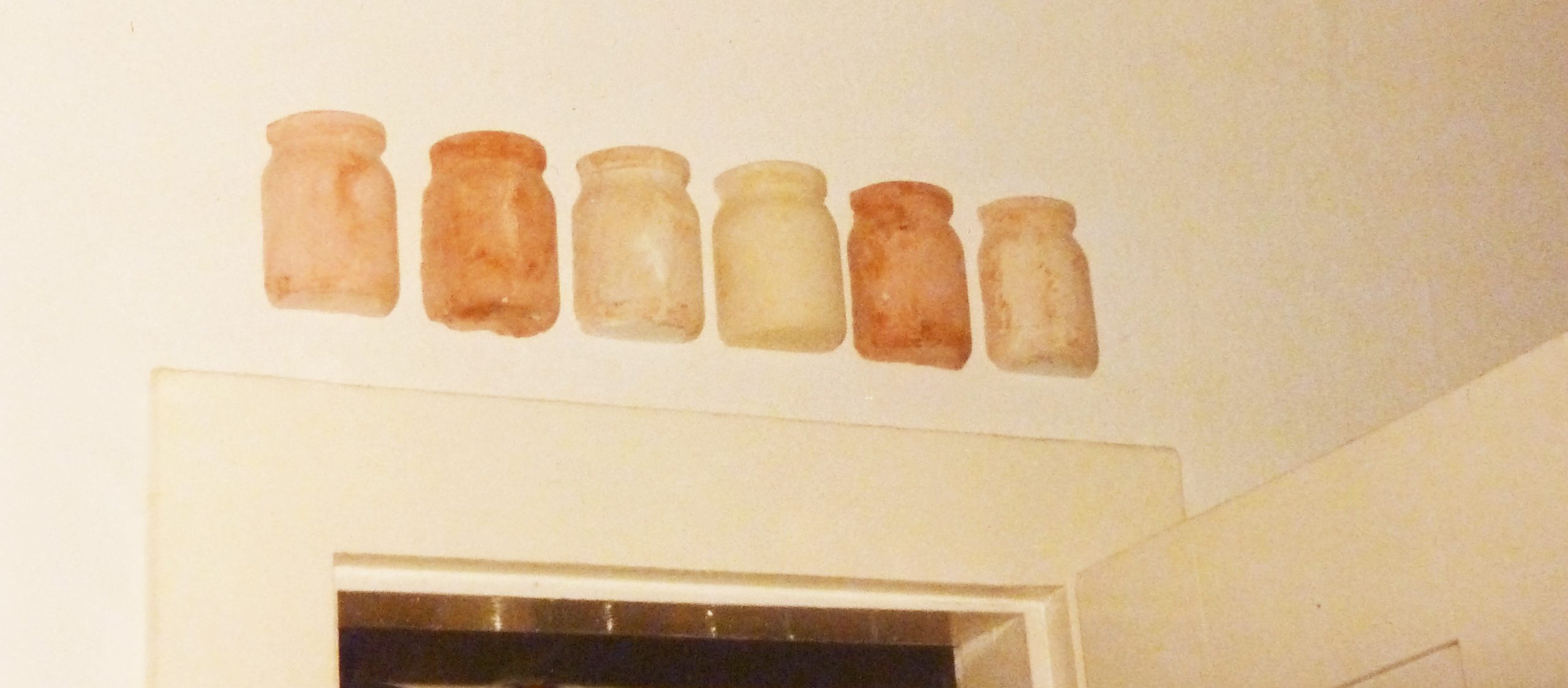 vergilbtes Foto einer Wandgesteltung aus Gipsabgüssen der Marmeladengläser