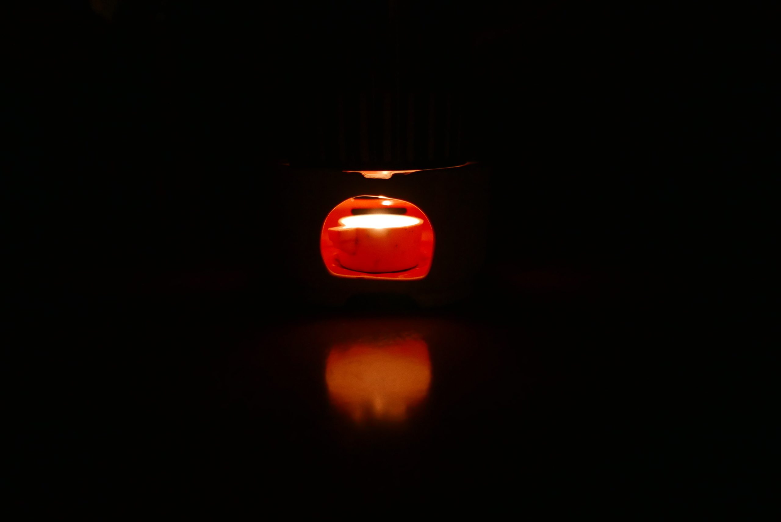 Rotes Licht und Spiegelung vom Stövchen auf dem Tisch