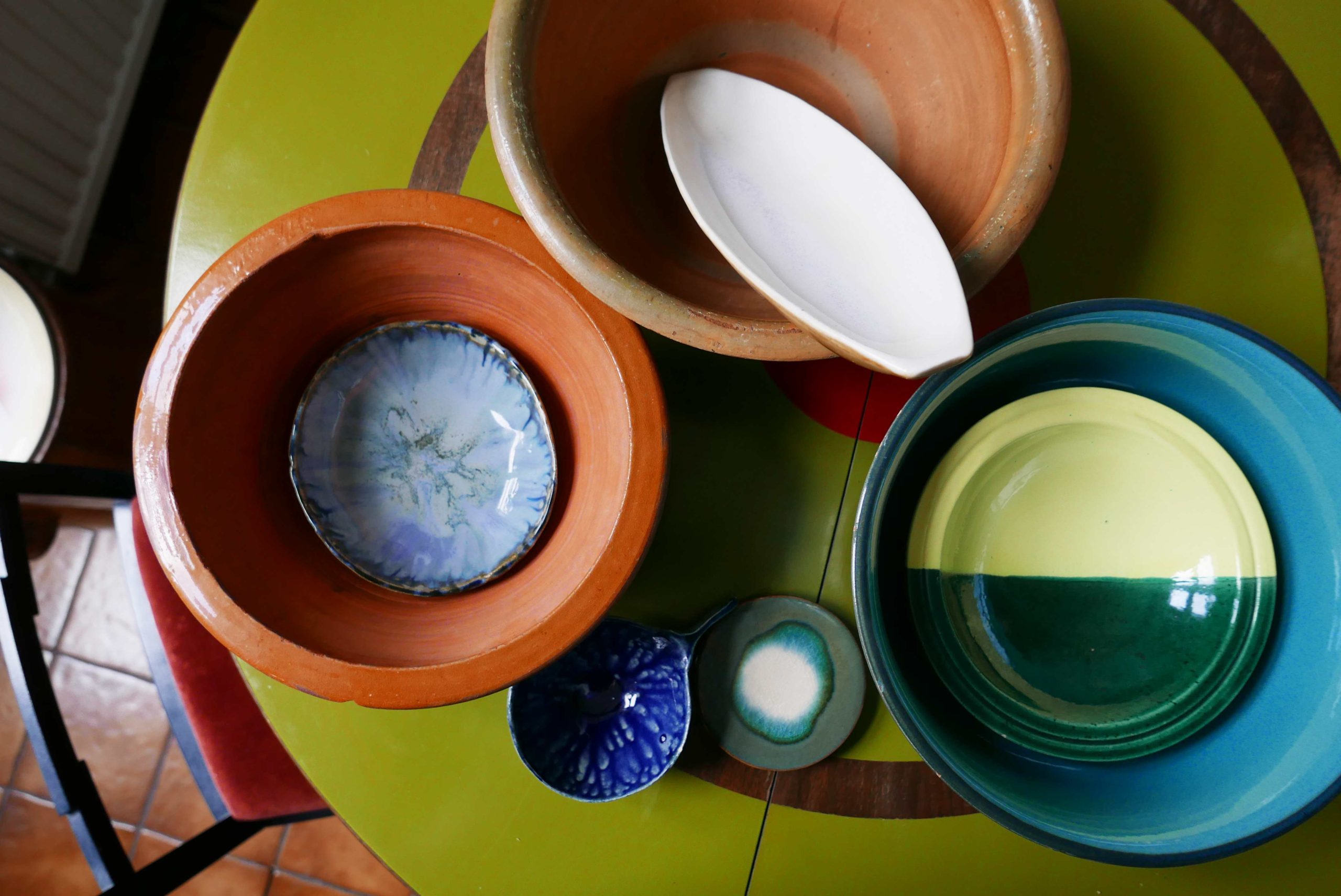 Verschiedene Schalen und Schüsseln aus Keramik auf einem runden Tisch